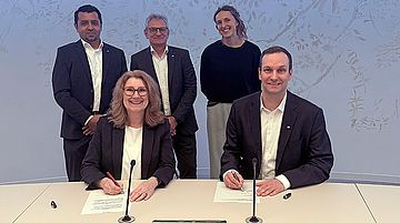 Bei der Vertragsunterzeichnung in Köln an einem Tisch in einem hellen Raum sind folgende Personen zu sehen: (vordere Reihe) v. l.: Ulrike Franzke, Vorständin der StEB Köln, Sebastian Kirchmann, Geschäftsführer der Stadtwerke Schwerte, (hinterer Reihe) v. l.: Scharuch Hessam (Prokurist SEG), Markus Borchert (Prokurist SEG) und  Projektverantwortliche Lea Steyer (StEB).