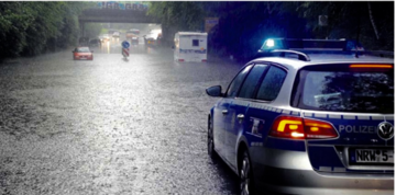 Ein Polizeiwagen auf einer überfluteten Straße